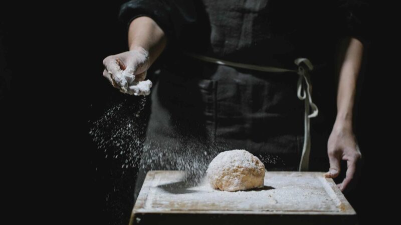 Ένας ζαχαροπλάστης ρίχνει αλεύρι στην ζύμη της Helmind